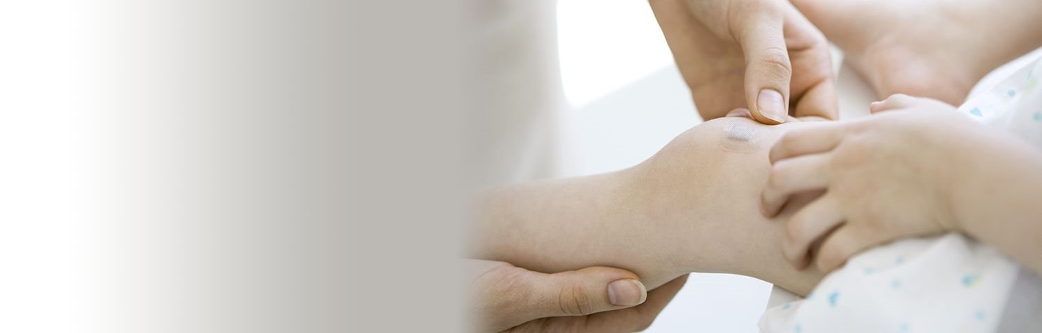 Manos de una mujer poniéndose apóstitos Hansaplast en los dedos